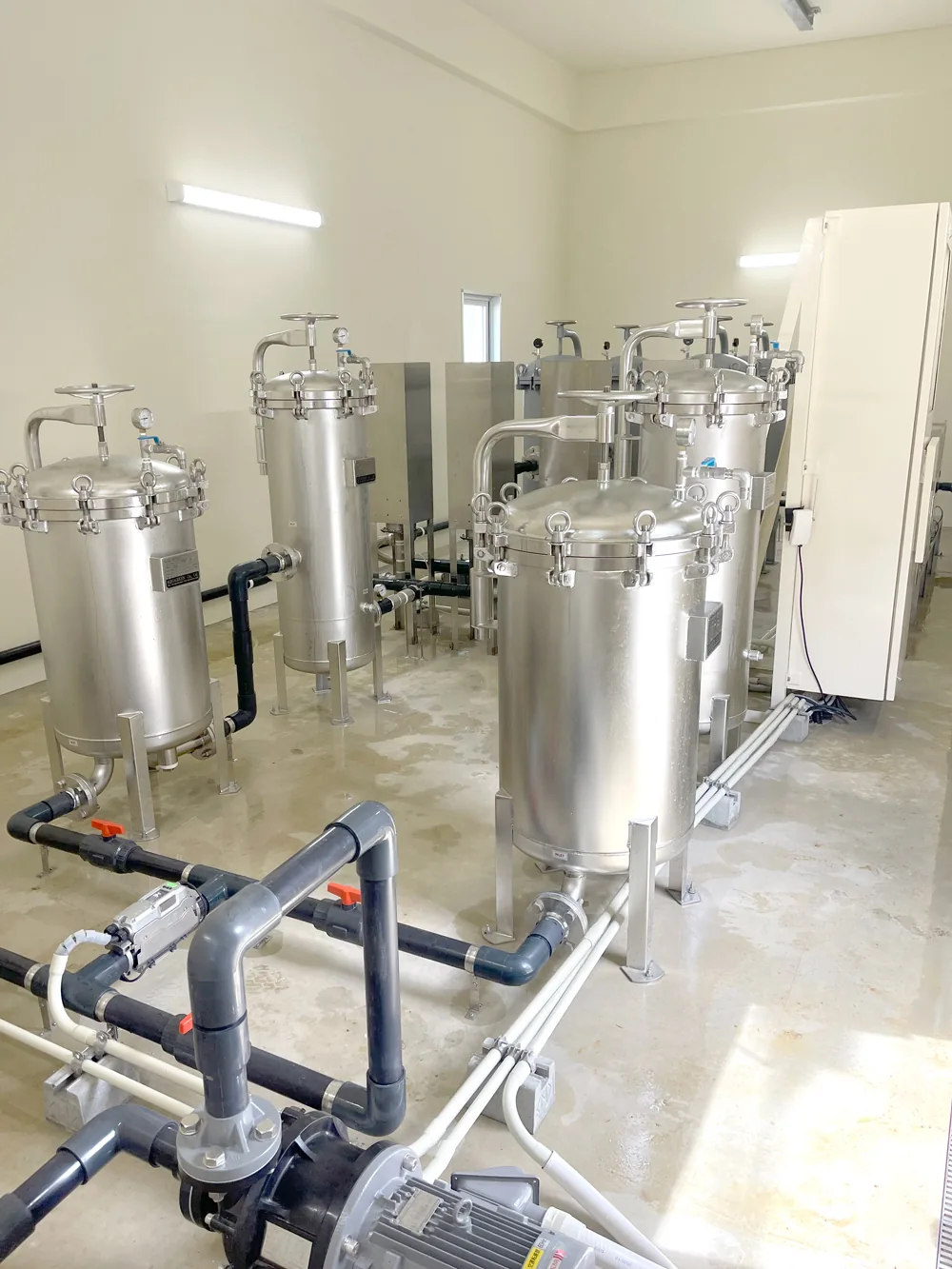 ステンレス製のろ過タンクと配管が並ぶ PFAS 除去プラントの内部